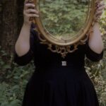 Personal Growth - Woman Holding Mirror Against Her Head in the Middle of Forest